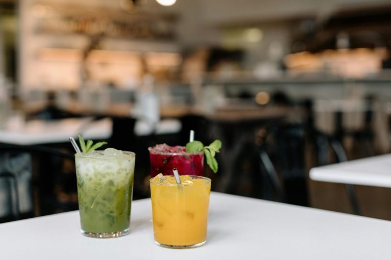 Vibrant trio of fresh fruit juices on a table in a trendy Seattle cafe. Perfect for lifestyle and food blogs.